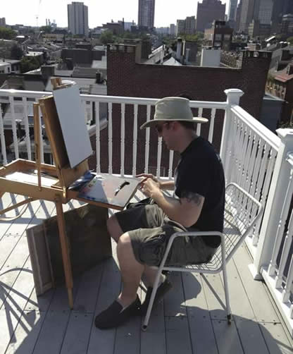Aaron Thompson painting on a rooftop in Philadelphia